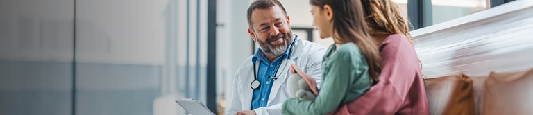 A male doctor talking with women and her daughter