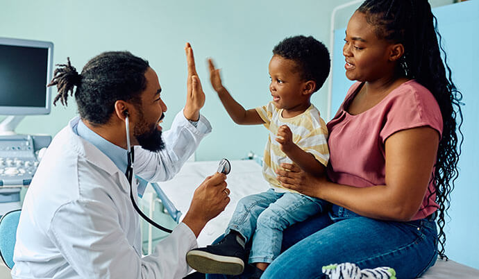 A pediatrician giving a child a high five