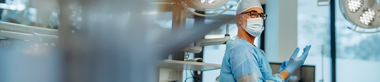 A surgeon putting on a glove