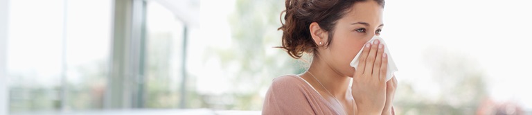 A woman blowing her nose