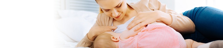 A woman breastfeeding at home