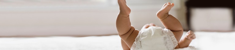 Baby in a diaper feet in the air
