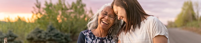 Two women leaning their heads on each other