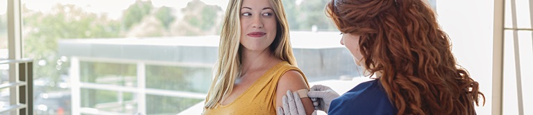 Nurse applying a band aid after a shot.