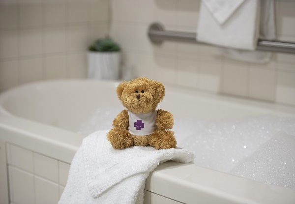 stuffed bear sitting on infant bathing area