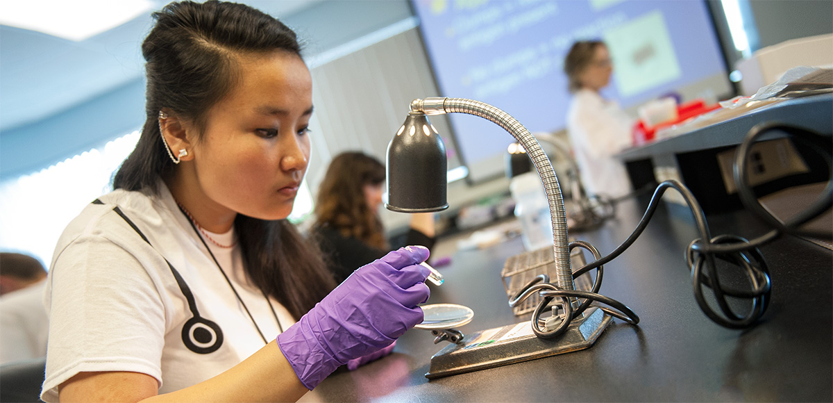 Student inspecting a slide with a microscope