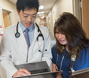 Resident talking with nurse outside patient's room