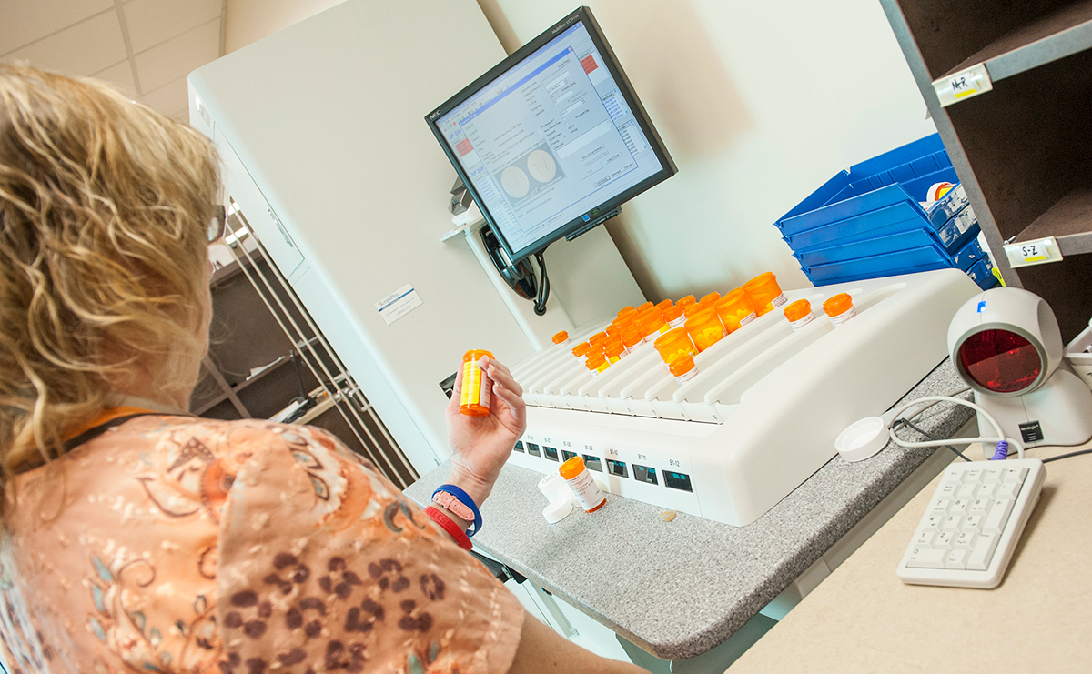 Person working with pharmacy dispensing unit