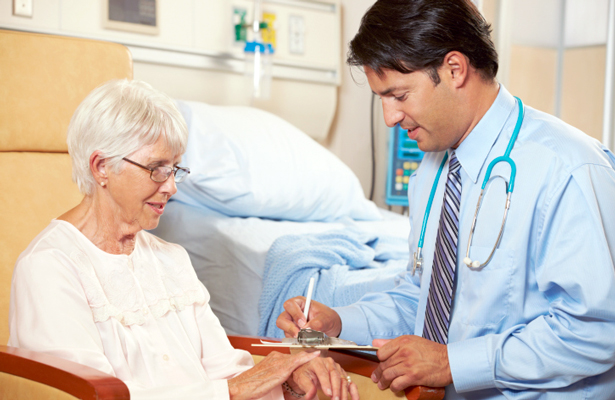 Medical doctor talks to elderly woman about her hand