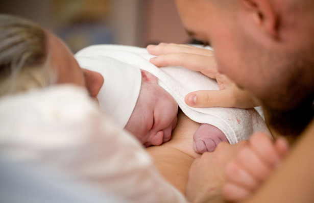 parents holding a newborn baby