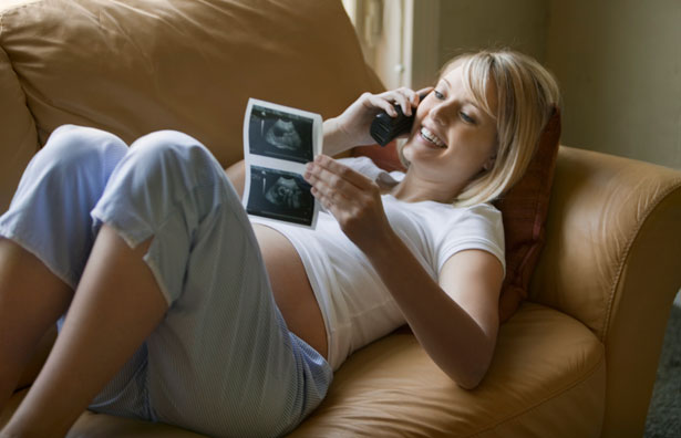 woman on phone looking at ultrasound scan