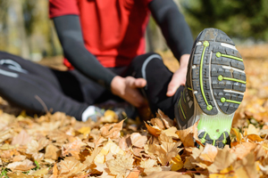 Athlete stretching, focus is on the sole of the shoe