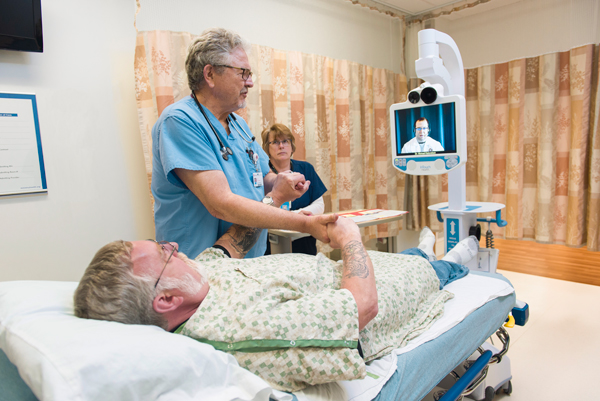 A Marshfield Medical Center provider and patient looking at a telestroke cart.