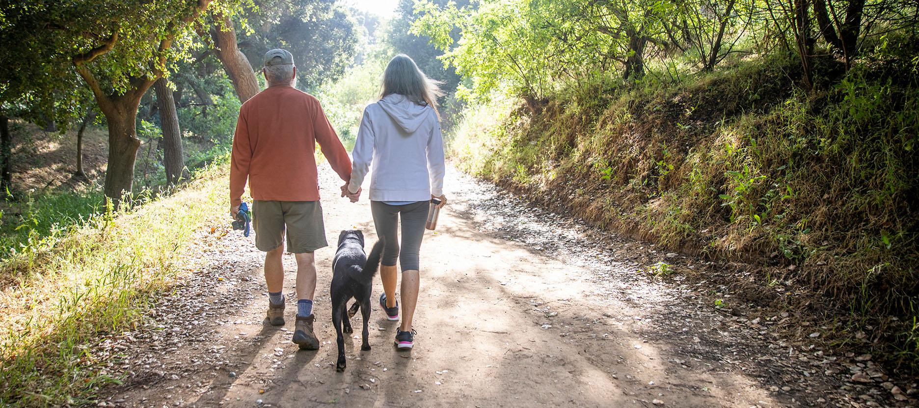 Couple walking down a scenic path on a sunny day