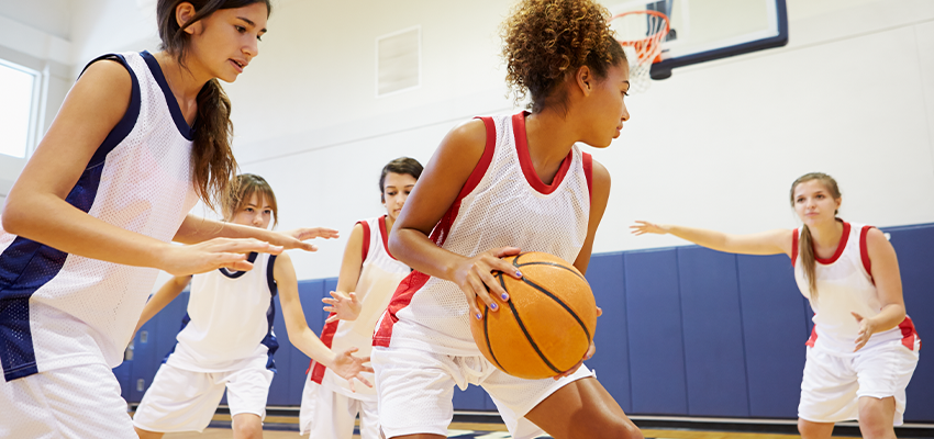 Image of teen female basketball players practicing together