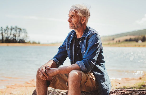 man sitting by a lake