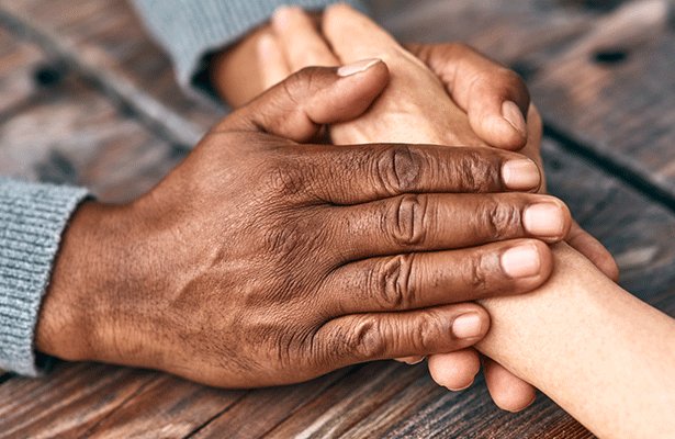 IMage of two individuals holding hands