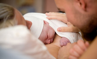 mom and dad looking at newborn